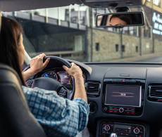 Women driving along empty city road